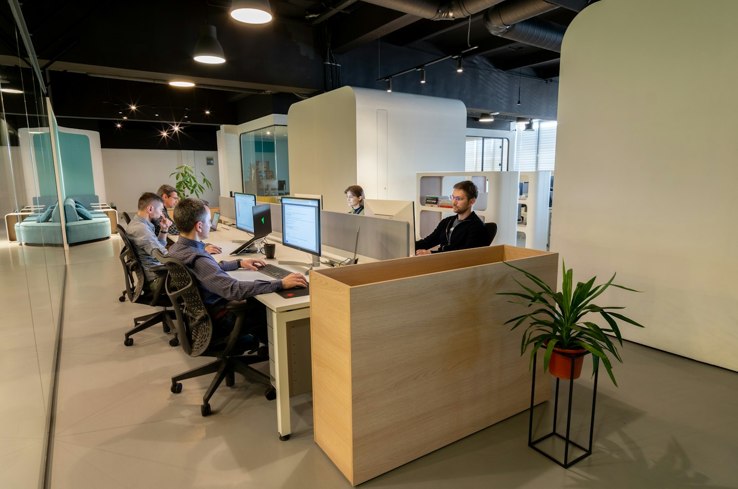 Professionelle, die in einem modernen Büro konzentriert an Computern arbeiten.