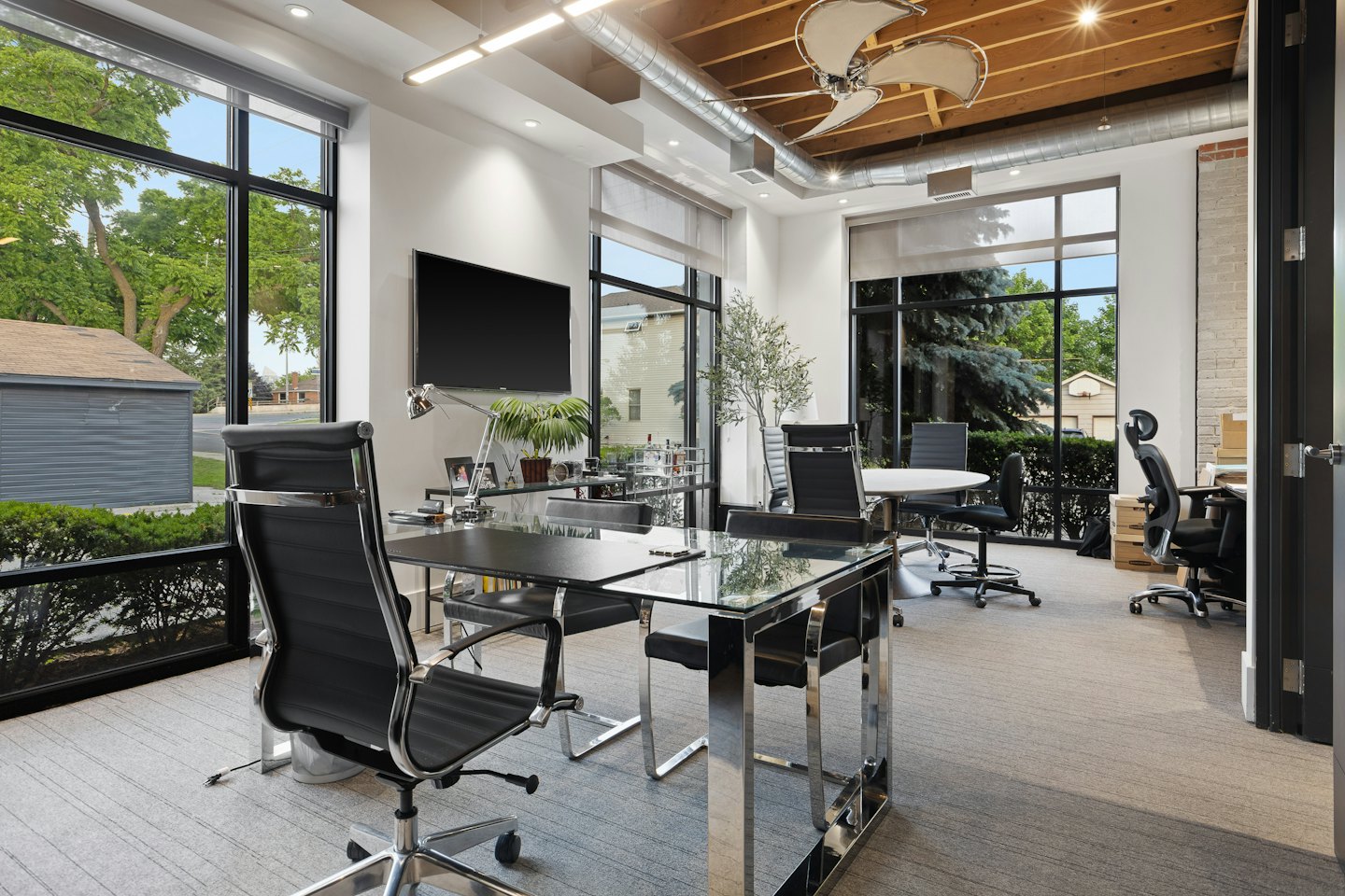 Modernes Büro mit Glastischen und ergonomischen Stühlen.