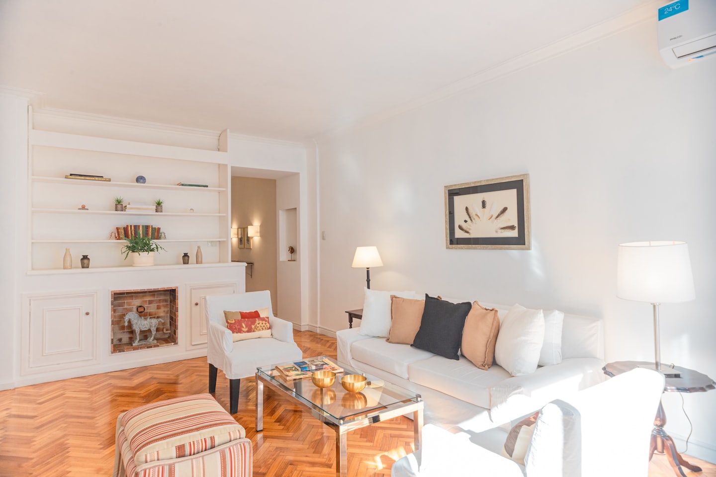 Modernes Wohnzimmer mit weißem Sofa und Glastisch.